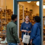 Local business owner engaging with customers in a welcoming storefront, emphasizing community and service
